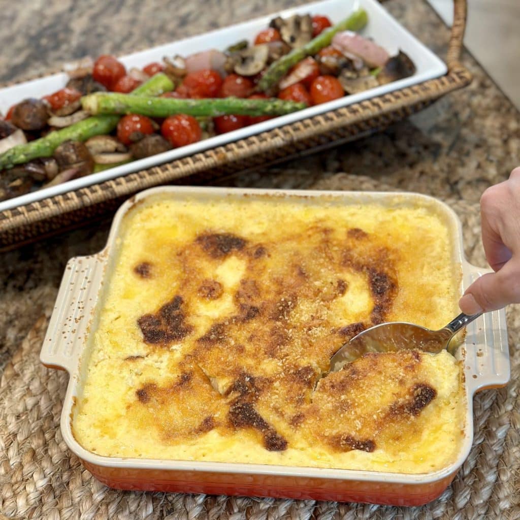 A pan of baked macaroni and cheese with vegetables on the side.