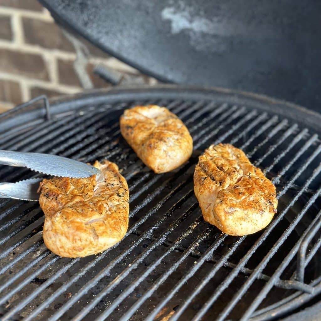 Flipping chicken on a grill.