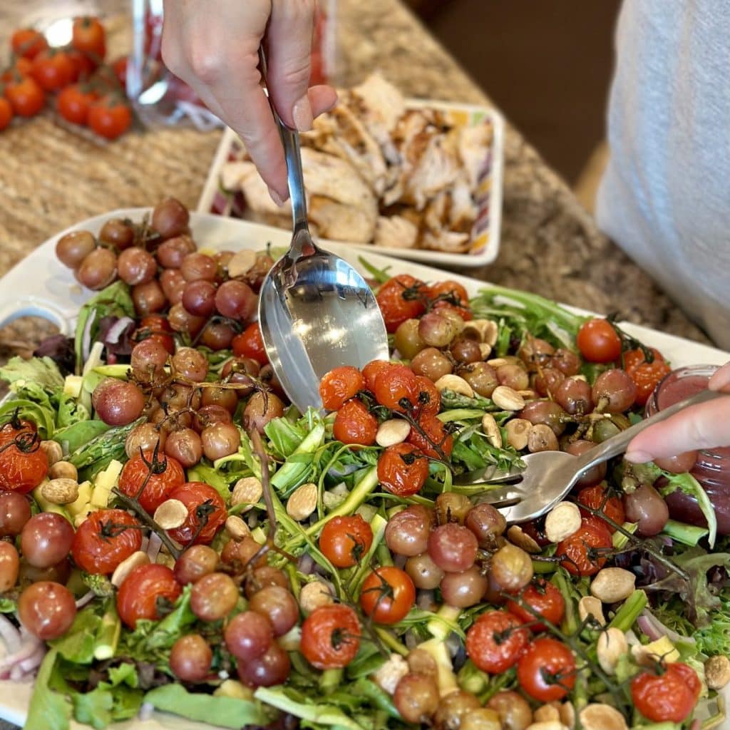 A person scooping up a serving of salad.