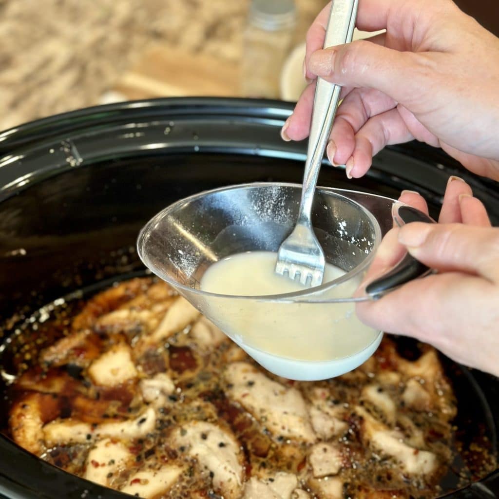 Whisking together a cornstarch slurry for a crockpot meal.