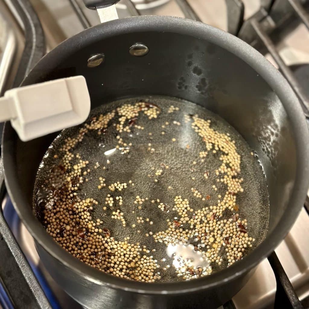 Brine in a saucepan ready to be poured on cucumbers In a jar.