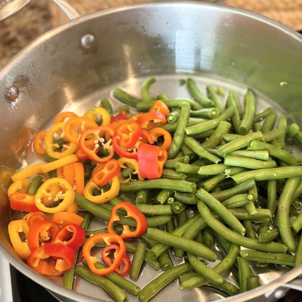 Stirring together a blend of vegetables in a skillet.