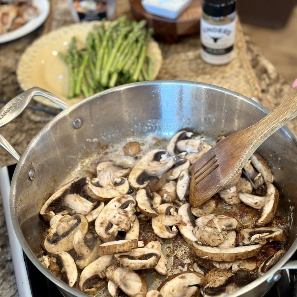 Stirring mushrooms in a skillet.