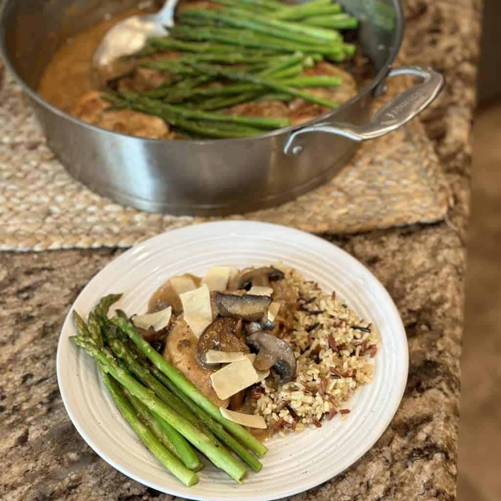 Dinner plate filled with chicken and asparagus.