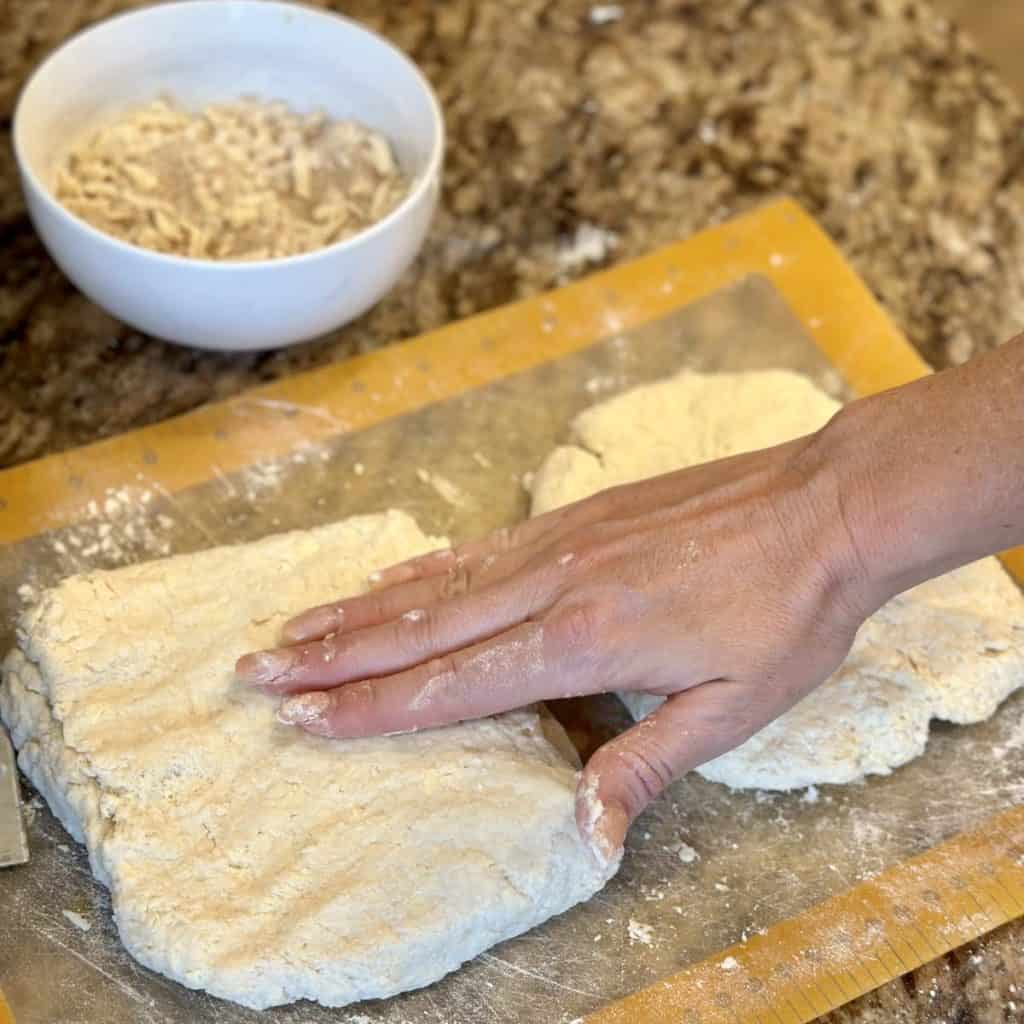 Patting biscuit dough on a mat.