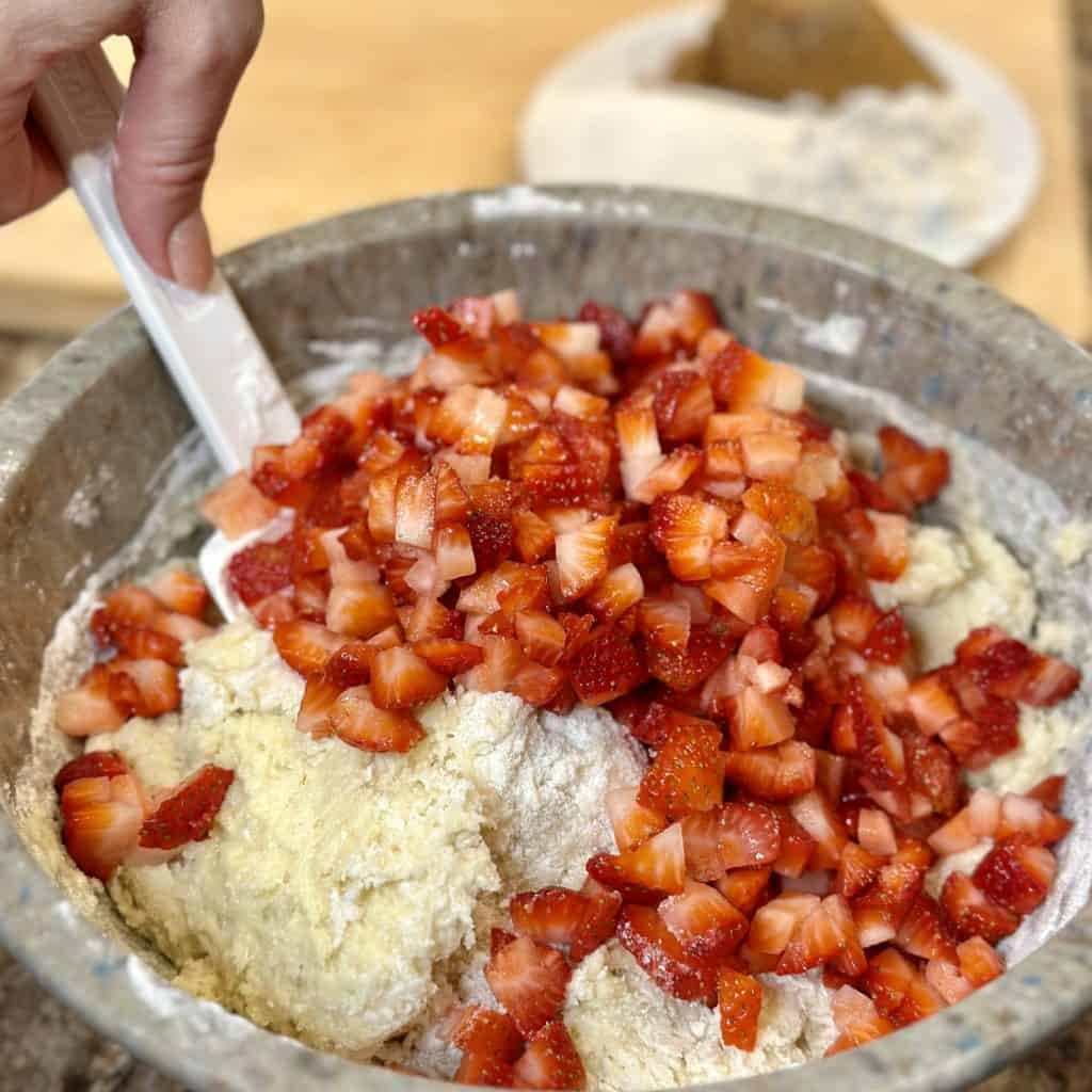 Folding strawberries into batter.