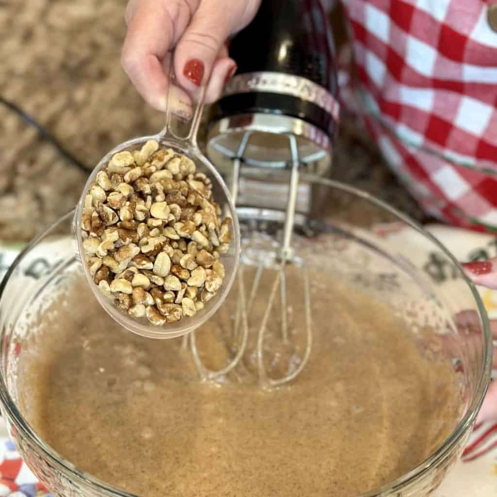 Adding walnuts to a cake batter.