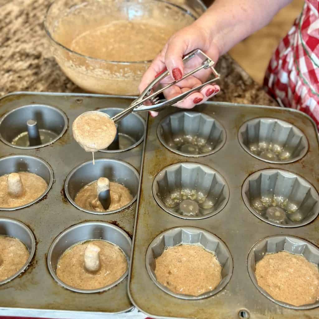 Scooping cake batter into a bundt pan.