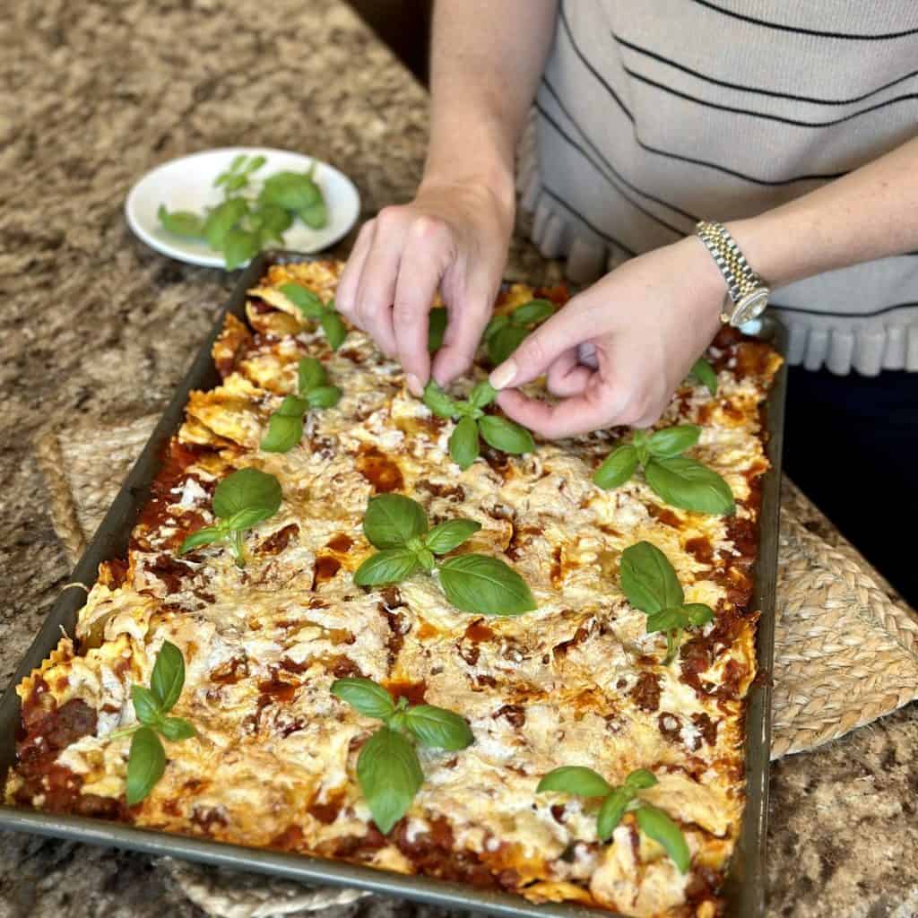 Laying basil on ravioli.