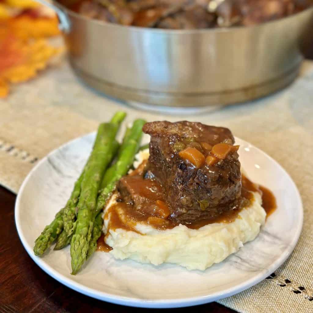 Braised short rib on potatoes with asparagus.