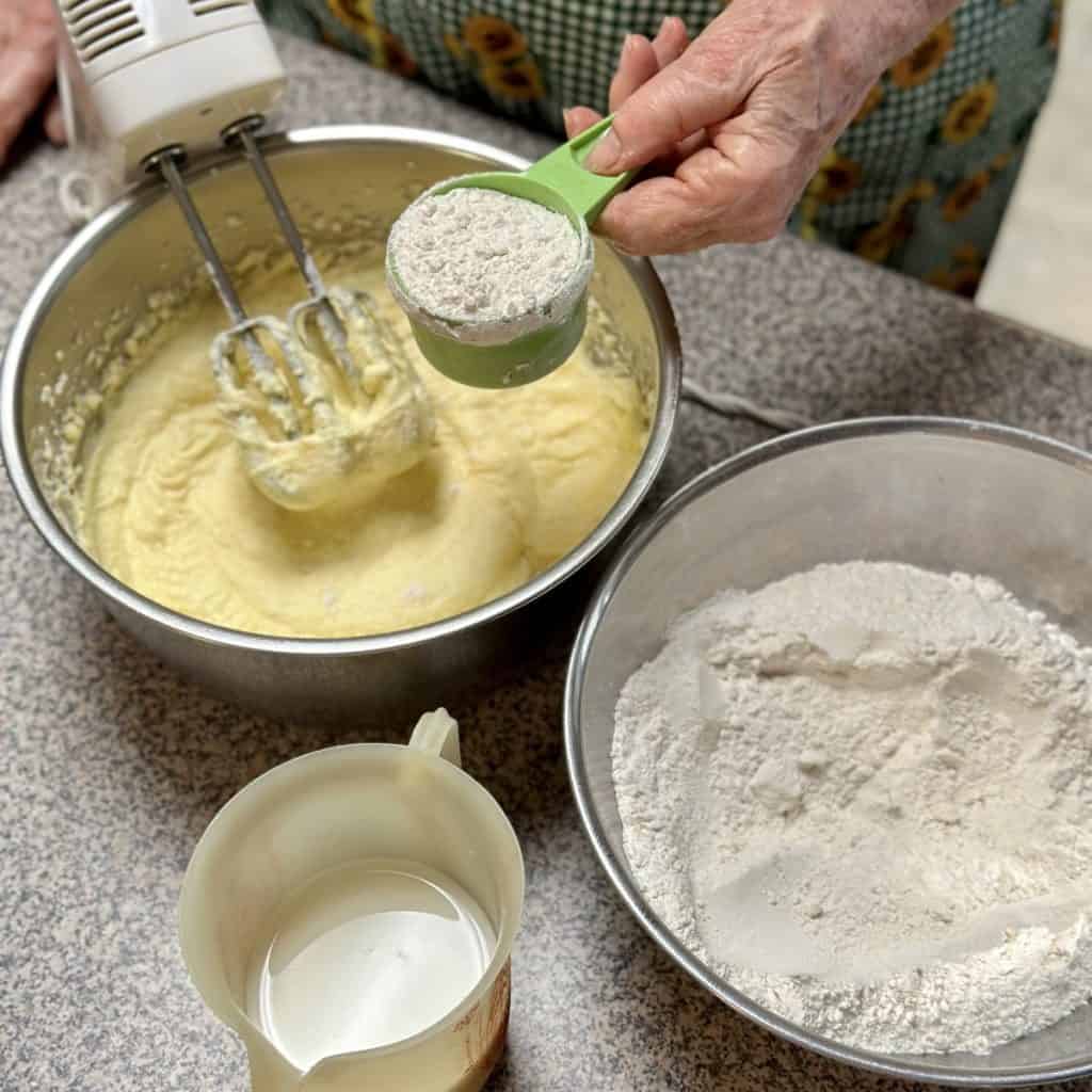 Adding wet and dry ingredients to a cake batter.