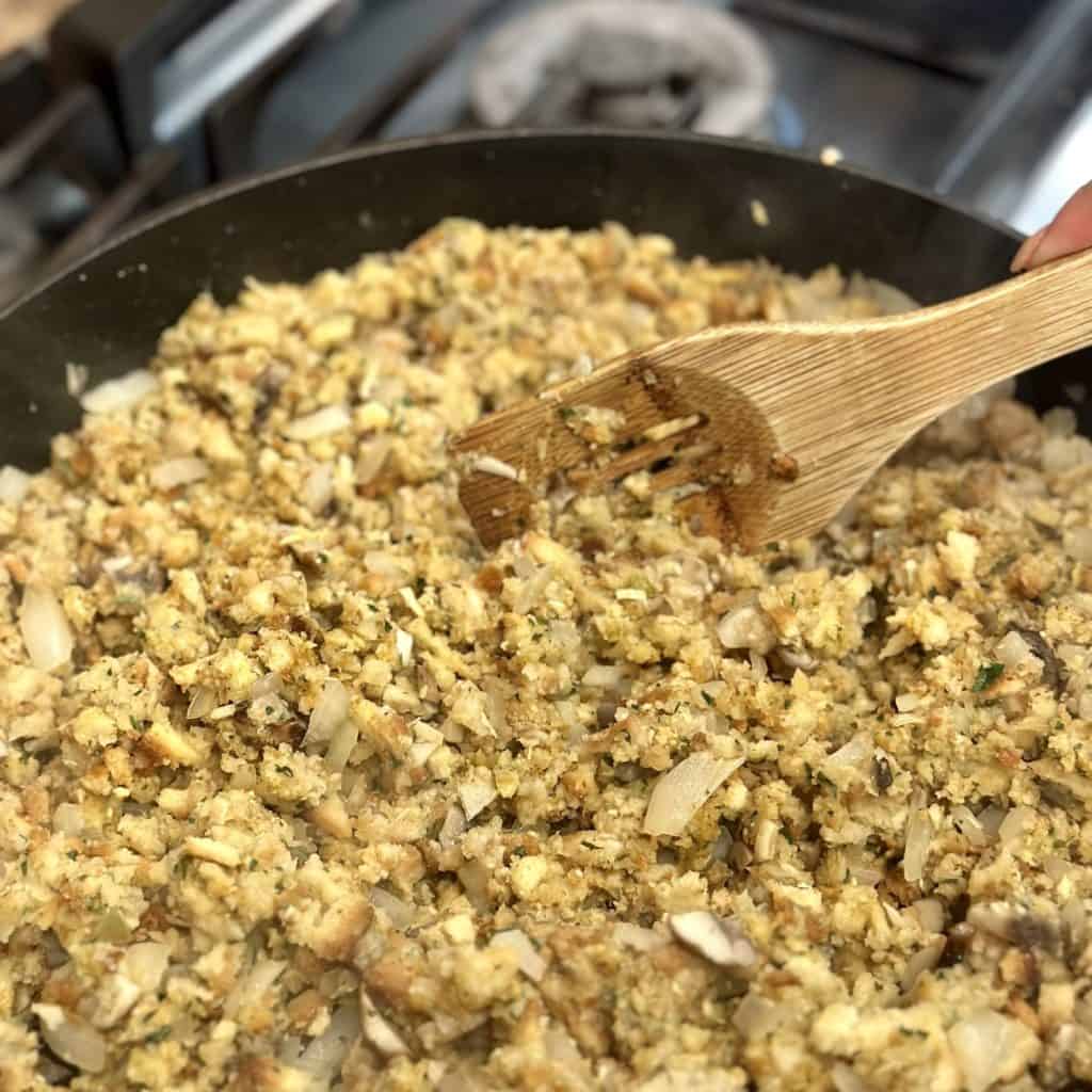 Mixing stuffing in a large skillet.