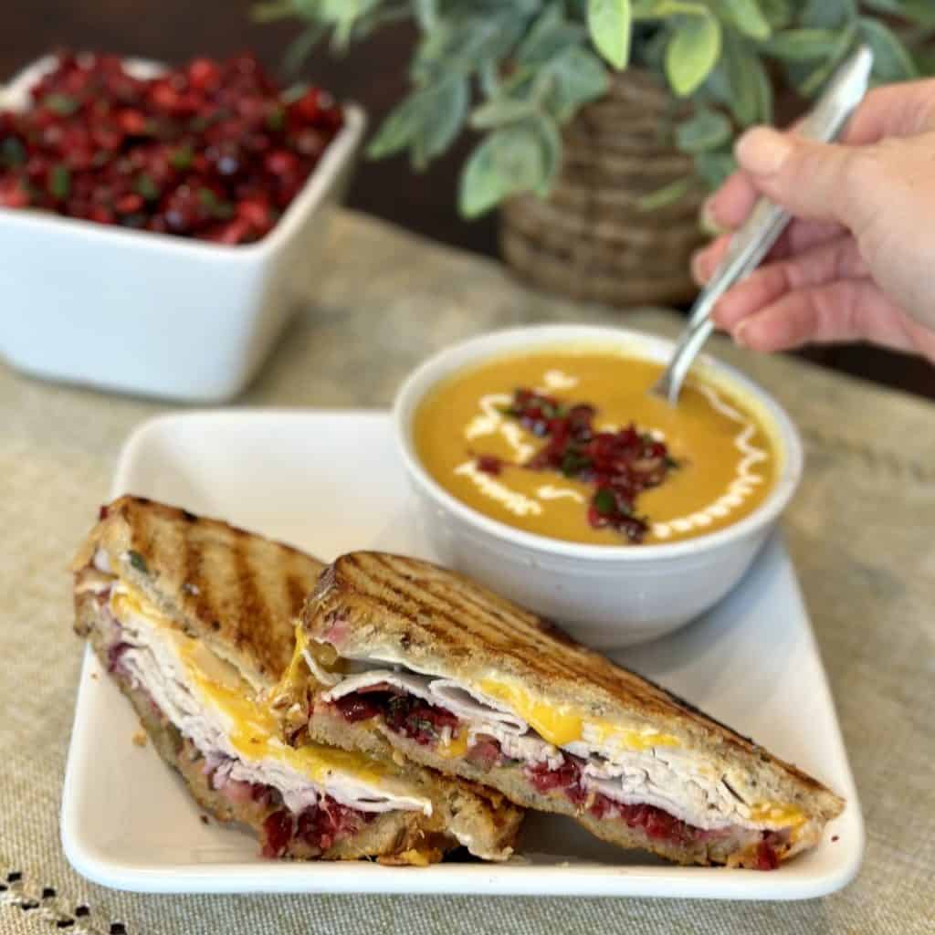 The gobbler sandwich with a bowl of pumpkin soup.