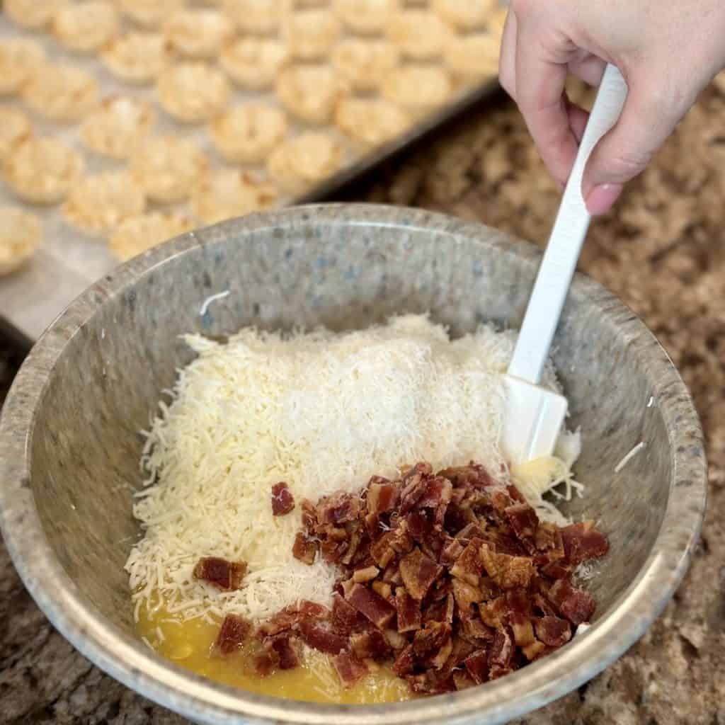 Mixing together a corn, cheese bacon filling for mini tart shells.