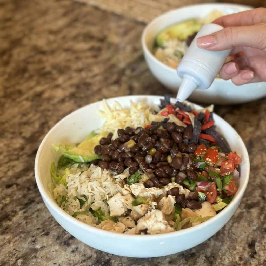 Adding dressing to a taco salad.