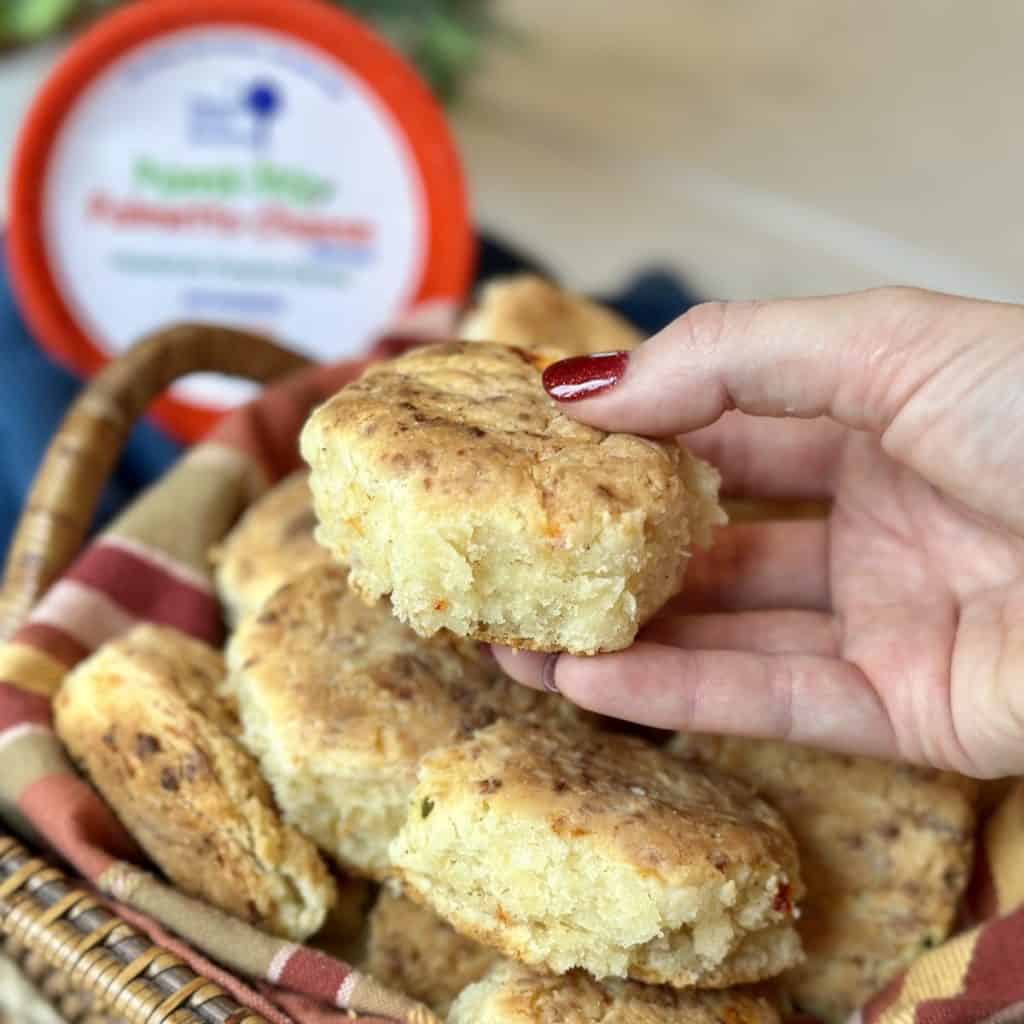 A hand holding a palmetto pimento cheese biscuit.