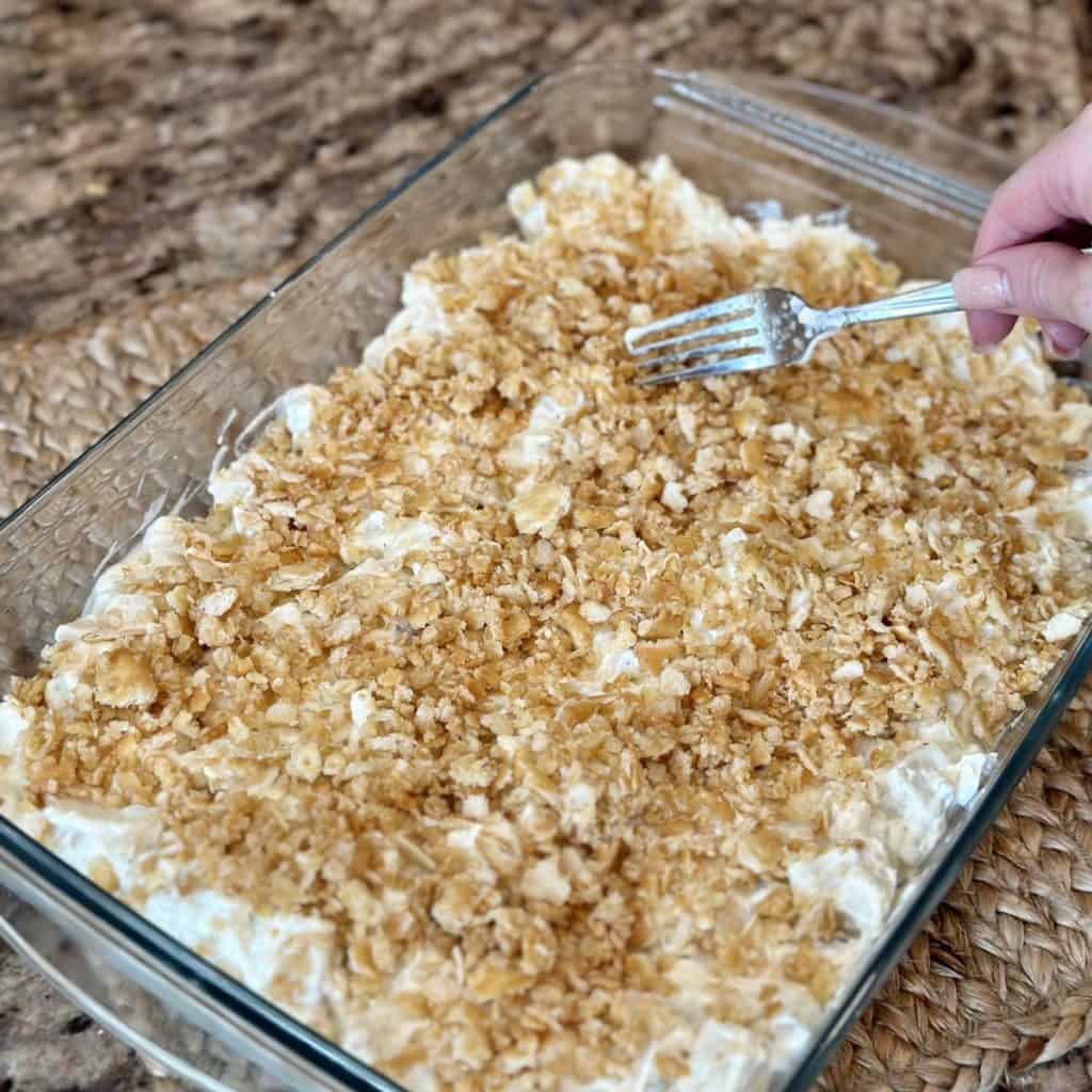 Adding a crumb topping to a potato casserole.