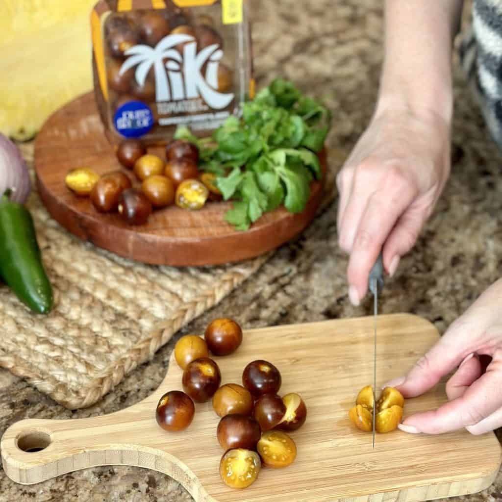 Quartering tomatoes on a cutting board.