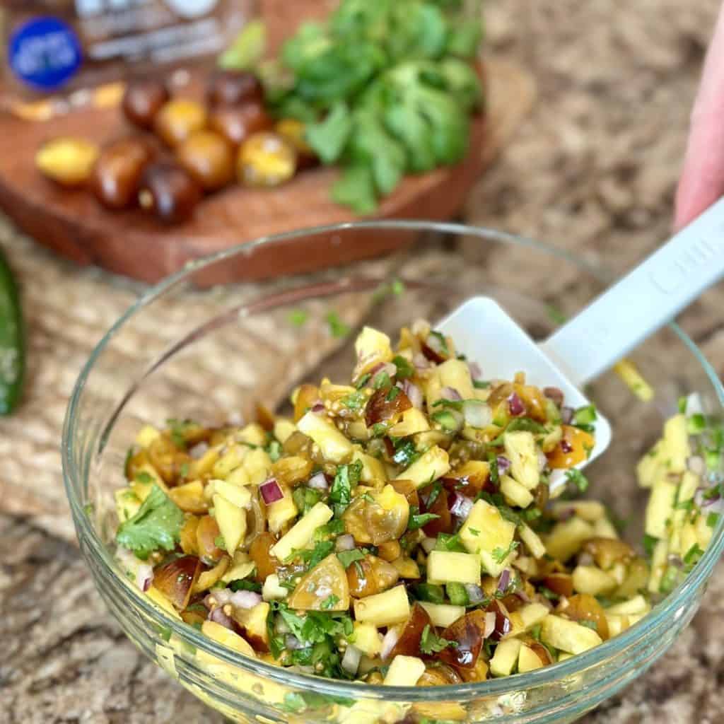 A bowl of mixed ingredients for pineapple pico de gallo.x