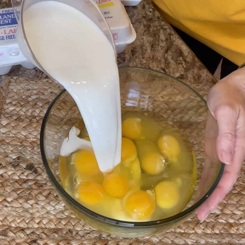 Pouring milk in a bowl of eggs.