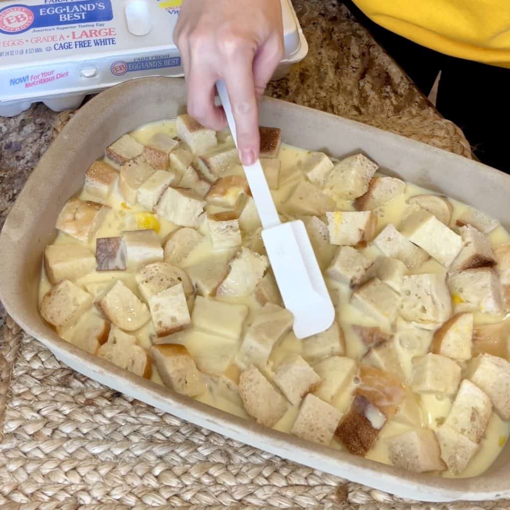 Pressing bread down into a custard mixture for French toast.