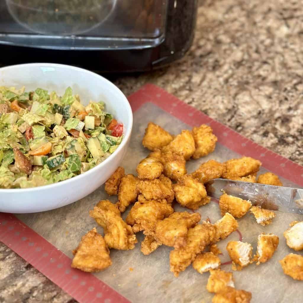 Cutting chicken into pieces for a salad.