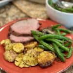 A plate of potatoes, beef and green beans.