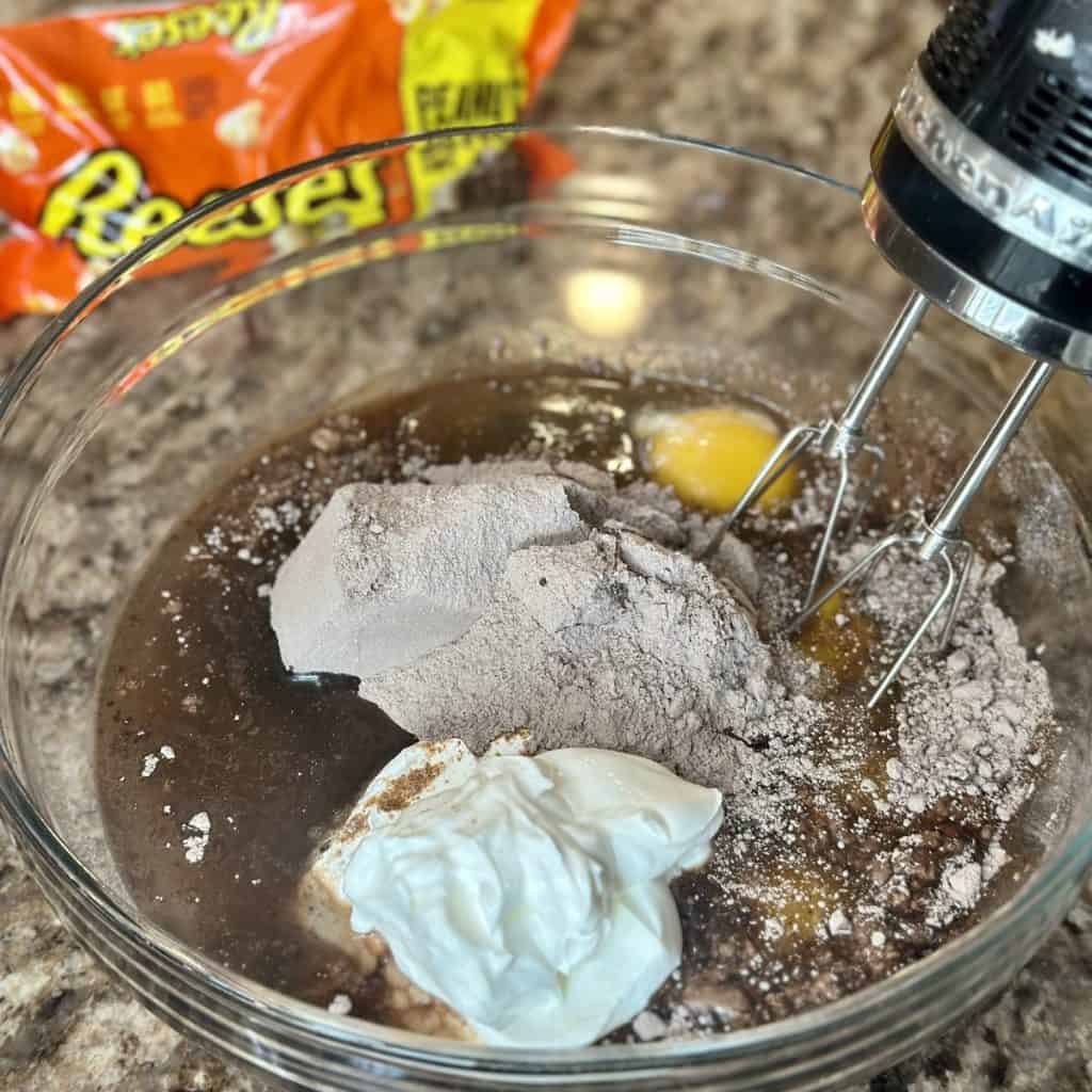 Mixing together a chocolate cake batter in a bowl.