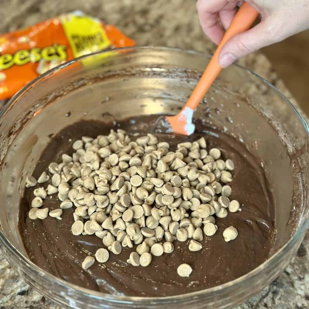 Folding peanut butter chips in a chocolate cake batter.