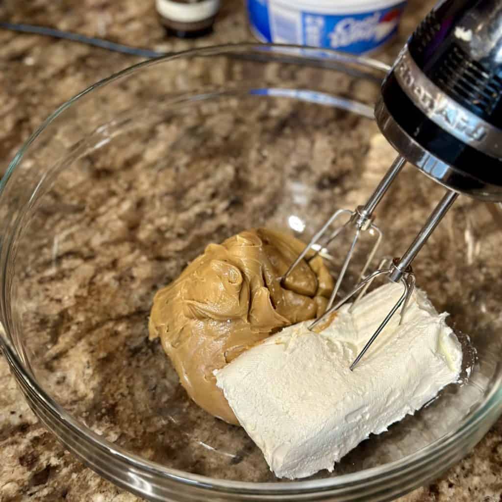 Mixing together peanut butter and cream cheese.