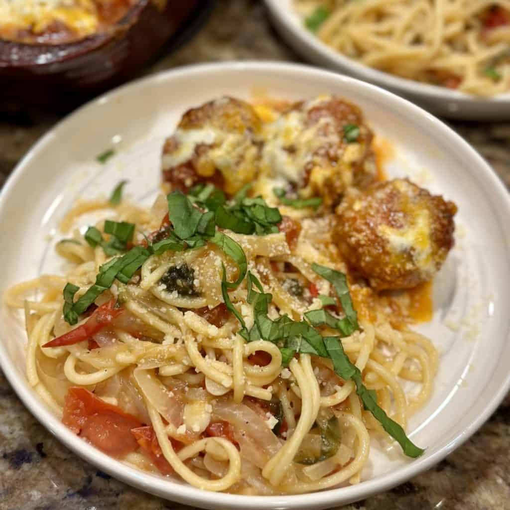 A plate of pasta and meatballs.