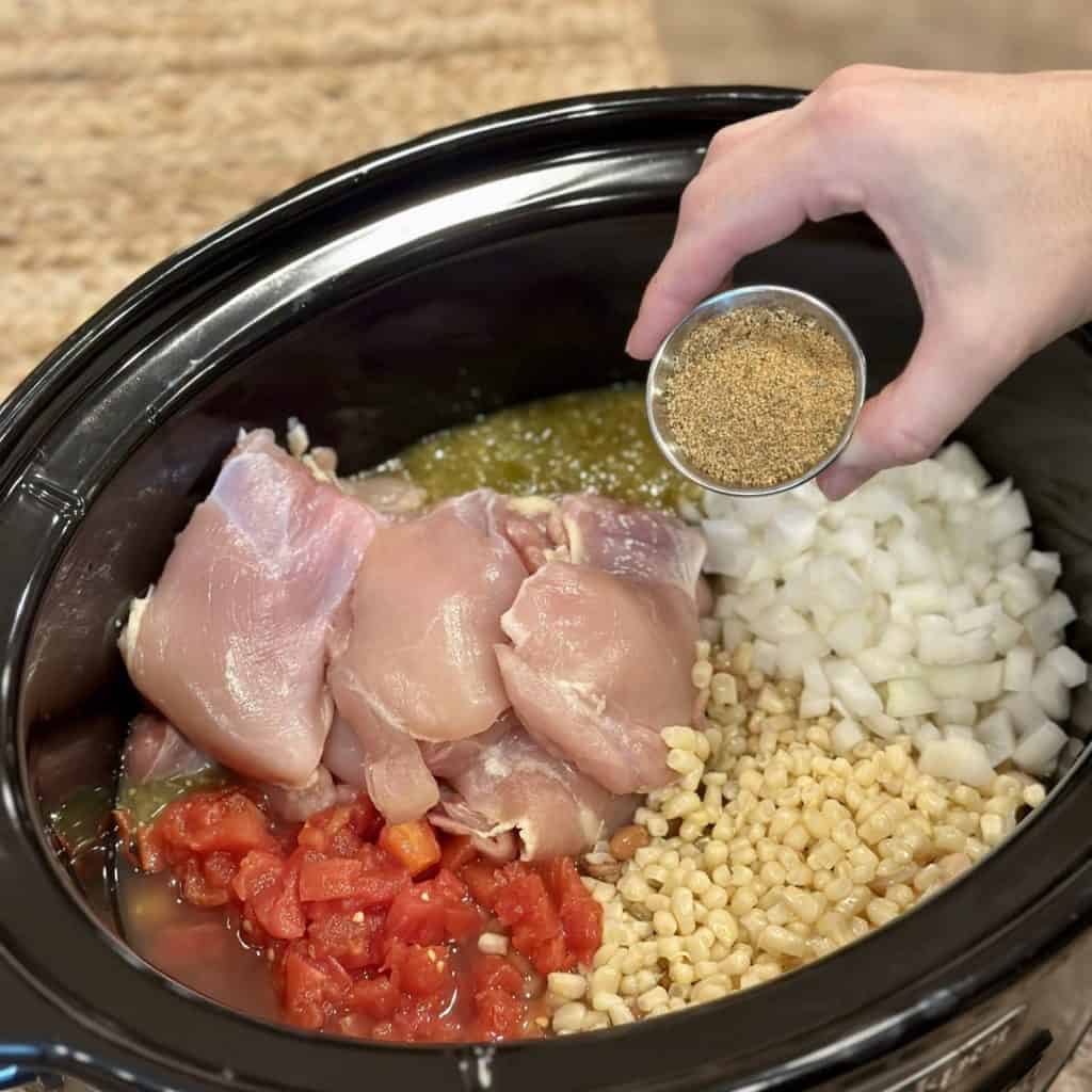 Adding the ingredients for white chicken chili in a slow cooker.