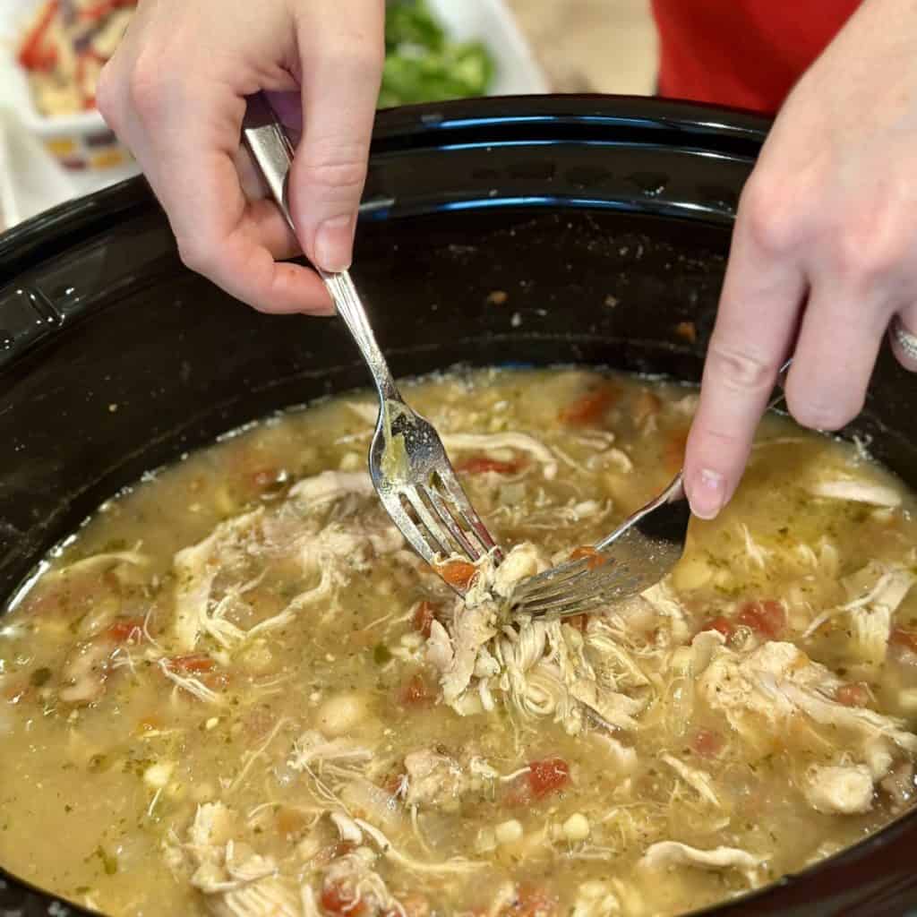 Shredding chicken in a crockpot in soup.