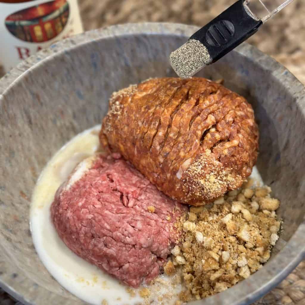 Adding ingredients for meatballs in a bowl.