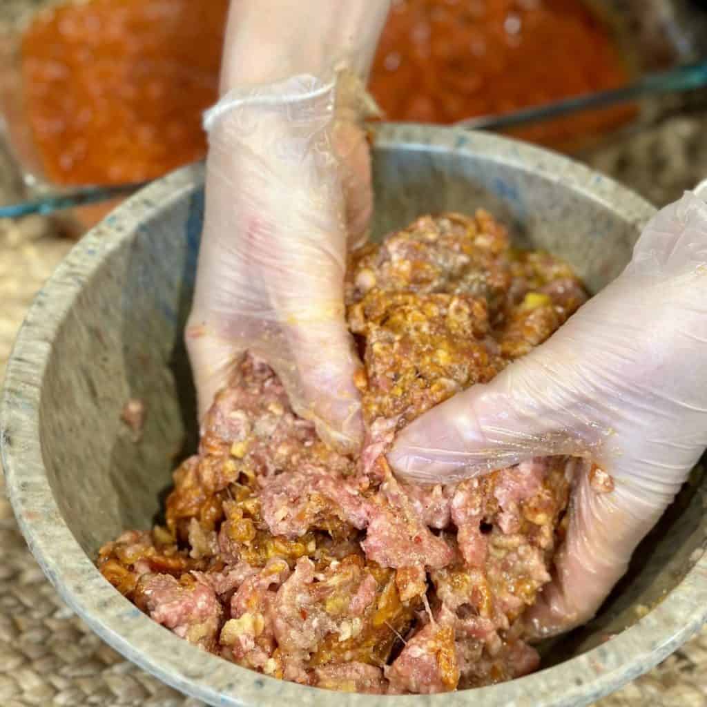 Mixing meatballs in a bowl.