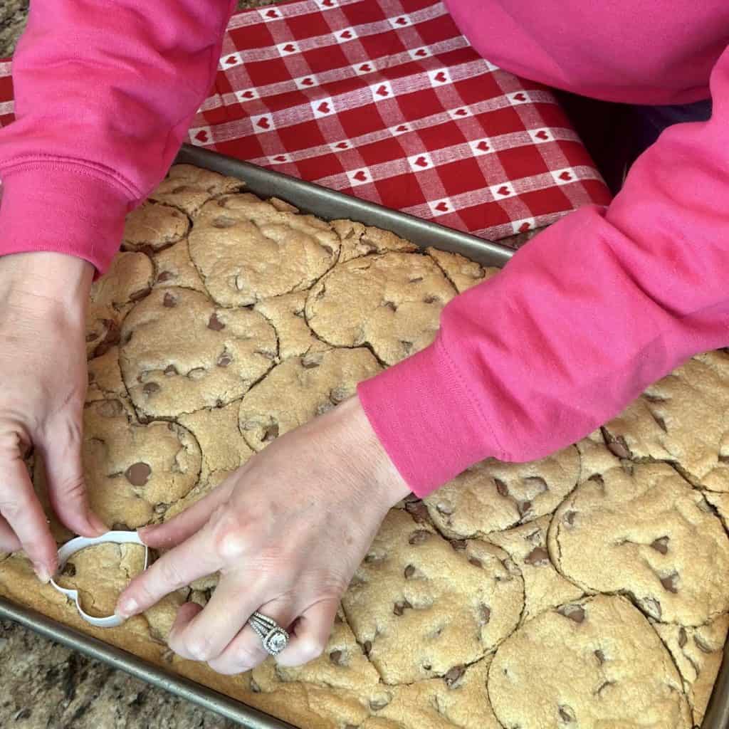 Cutting out hearts from baked cookie dough.