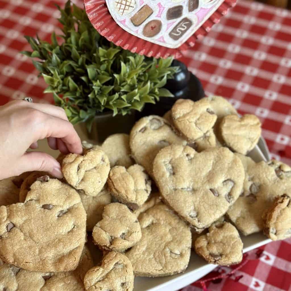 A plate of heart shaped chocolate chip cookies.