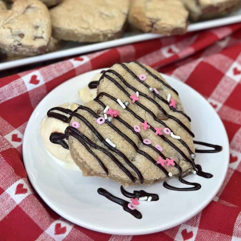 A chocolate chip cookie with ice cream and chocolate sauce.
