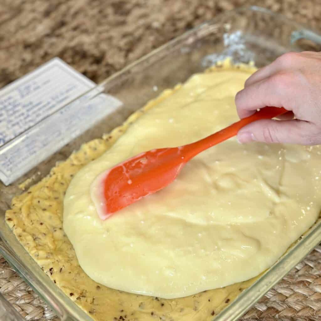 Spreading filling on a crust for Ooey Gooey Bars.
