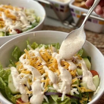 Adding dressing to the top of salad.