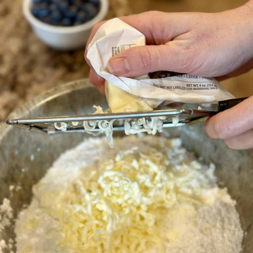 Grating butter in flour.