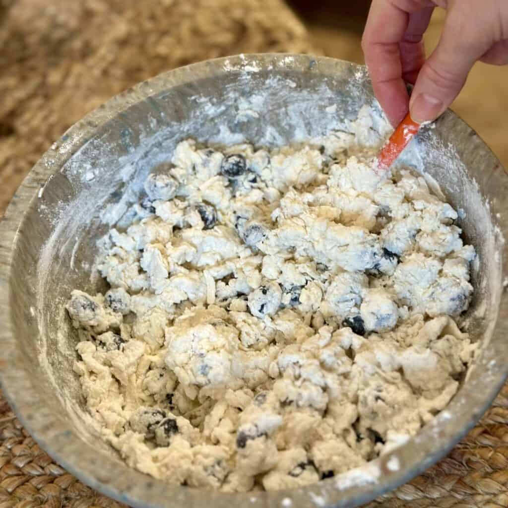 Mixing together blueberry biscuit dough batter.