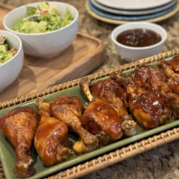 Barbecue chicken drumsticks on a platter.