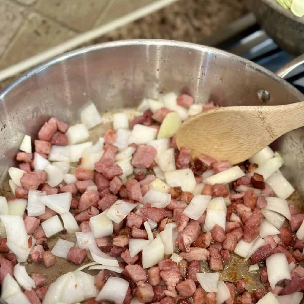 Sauteeing ham and onion in a skillet.