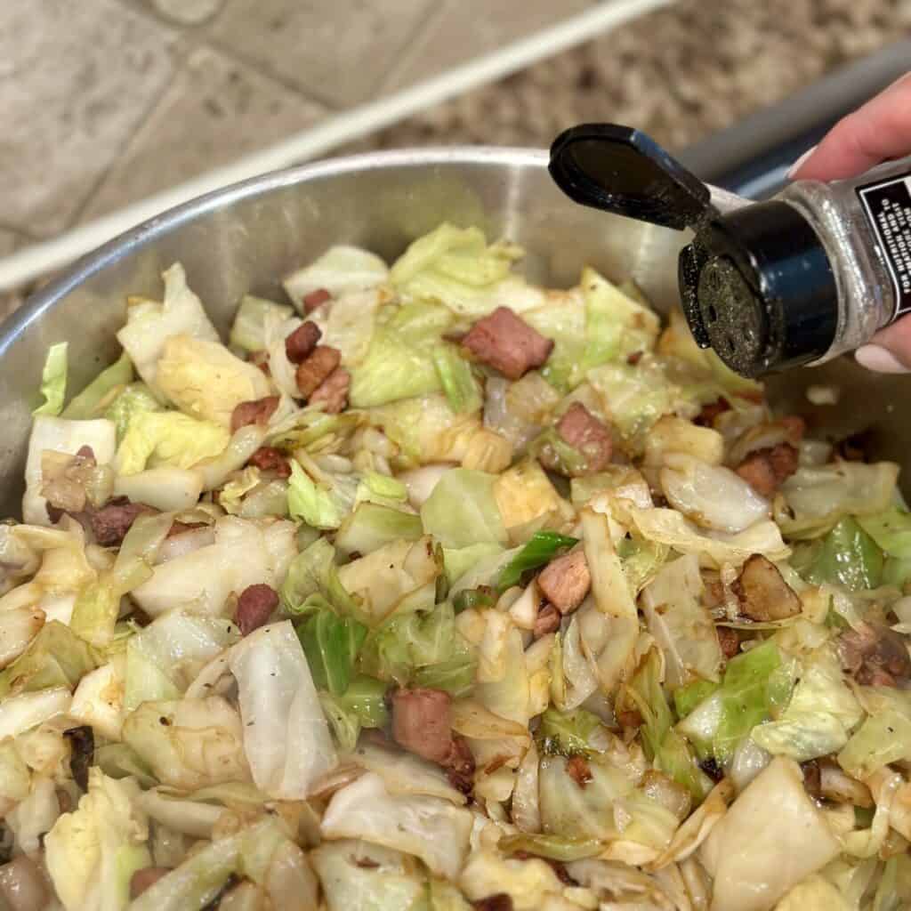 Cooking ham and cabbage in a skillet.
