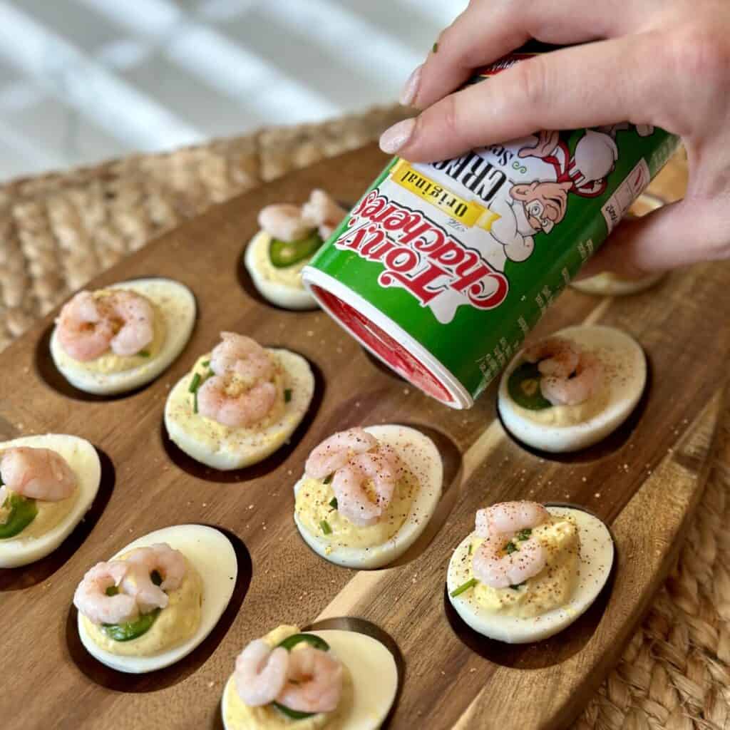 Adding Cajun seasoning to deviled eggs.