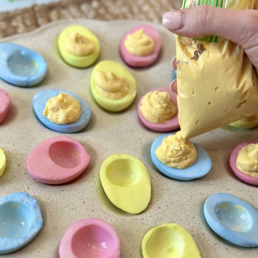 Piping yolk filling into an egg white.