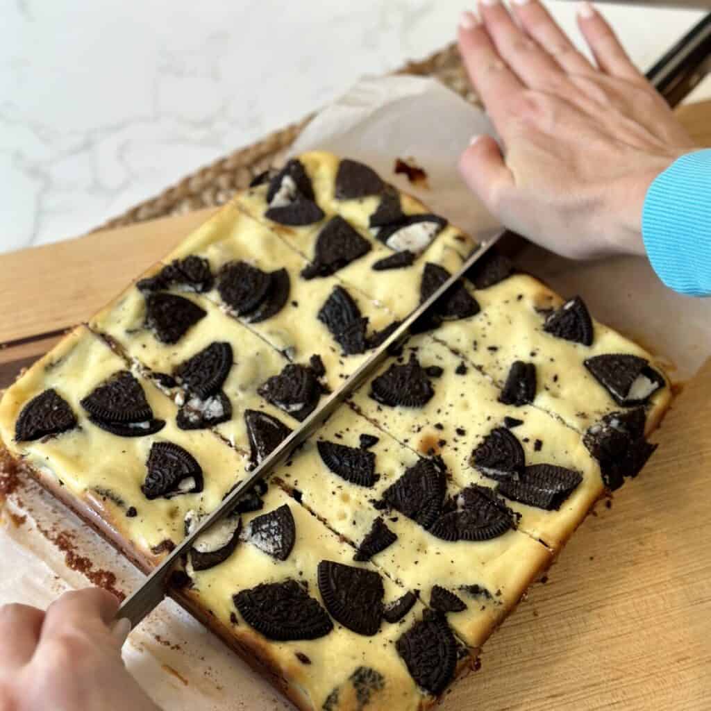 Cutting brownies on a cutting board.