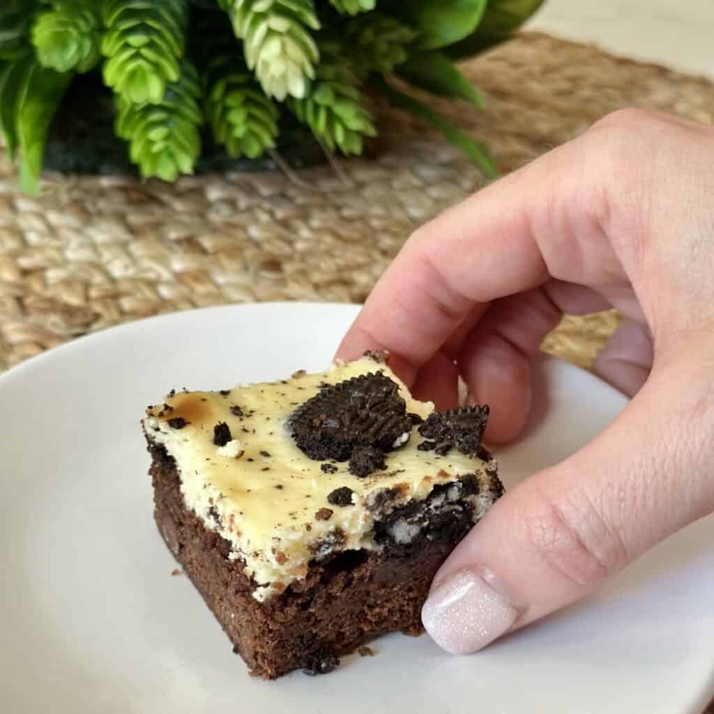 Holding an oreo cheesecake brownie.