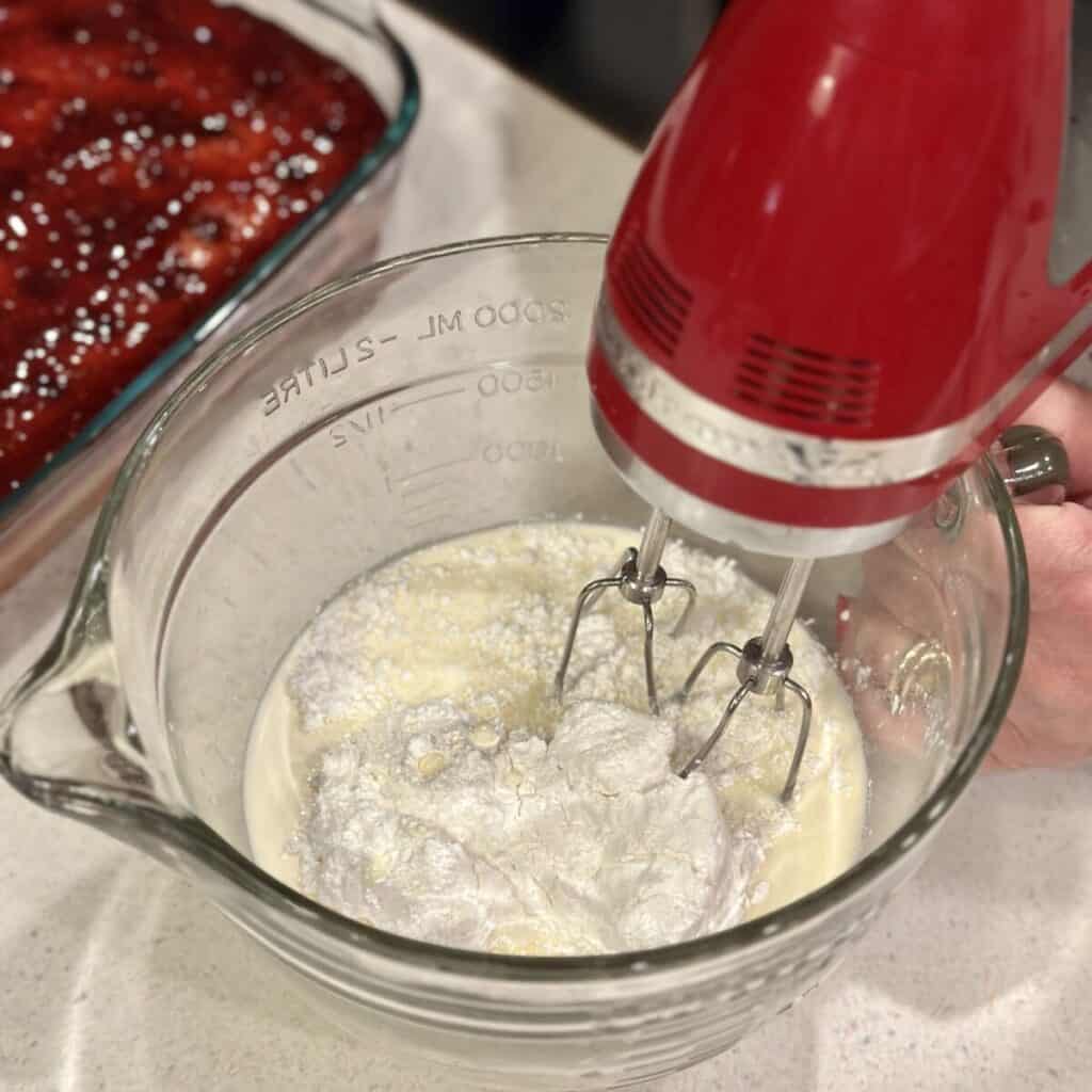 Whipping heavy cream and powdered sugar in a bowl. 